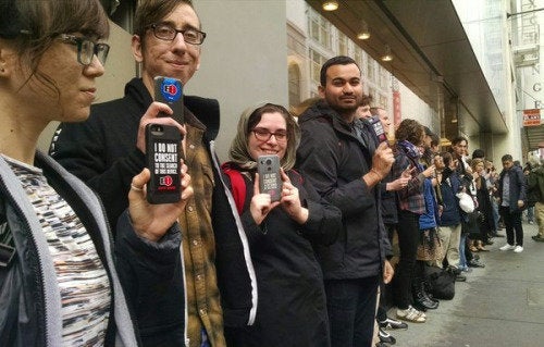 Dozens of protestors stand in solidarity with Apple outside the company's flagship store in San Francisco.