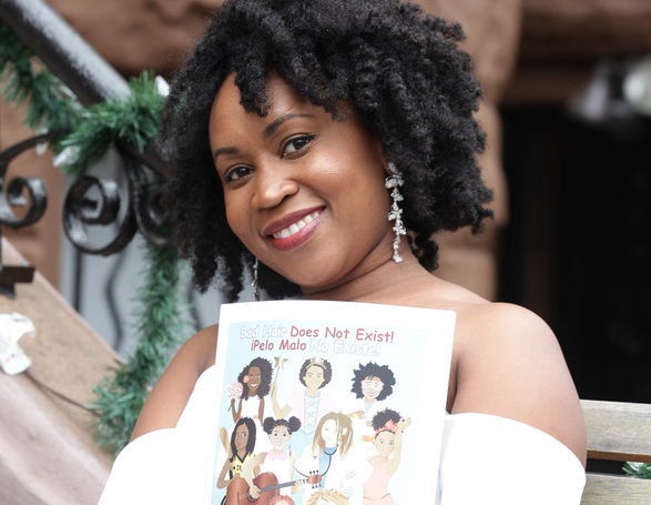 Sulma Arzu-Brown holding her book, Bad Hair Does Not Exist!