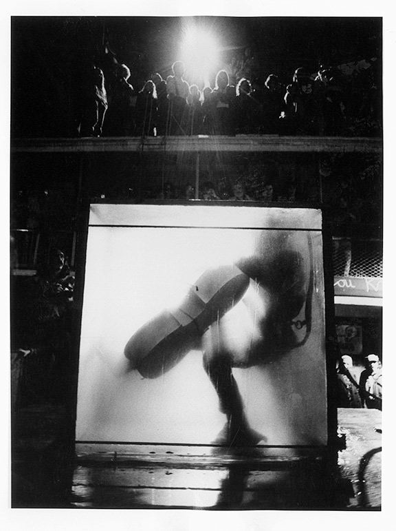 Peter Moore. Charlotte Moorman performs Jim McWilliams’s <em>The Intravenous Feeding of Charlotte Moorman</em>, 9th Annual New York Avant Garde Festival, South Street Seaport, October 28, 1972. Photograph c. Barbara Moore/Licensed by VAGA, NY.