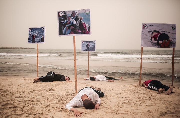 People lie on the Gaza beach to commemorate Alan Kurdi and 12 Syrians who drowned in the Aegean Sea after two boats filled with refugees en route to Greece sank, in Gaza City, Gaza, on Sept. 8, 2015. 