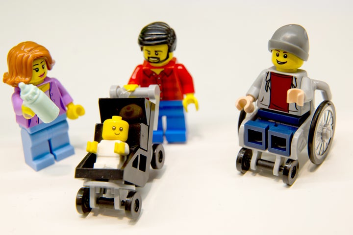 New LEGO minifigures, including a stay-at-home dad, working mom, baby in a stroller and young man in a wheelchair.