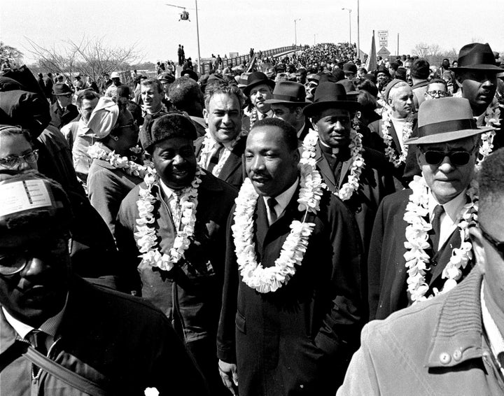 Martin Luther King Jr. leads a march for voting rights across Edmund Pettis Bridge in Selma, Alabama, on March 21, 1965. State troopers savagely beat the marchers.