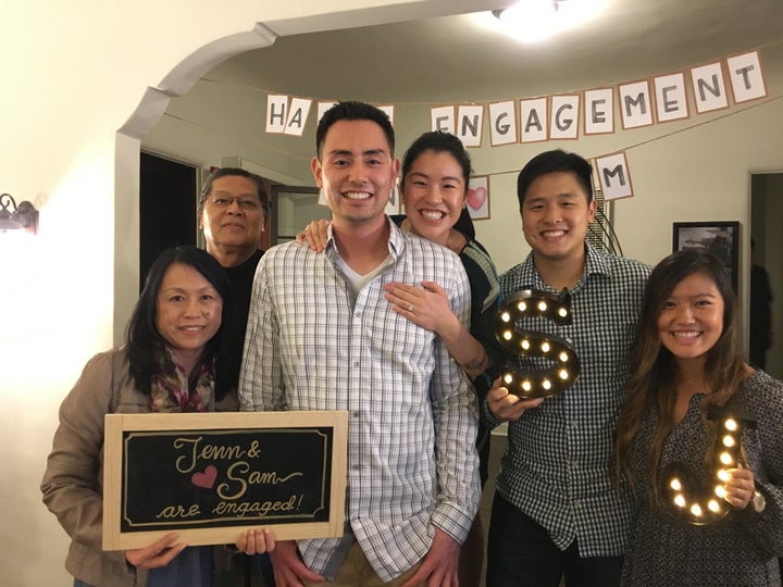 The ecstatic couple posing with family.
