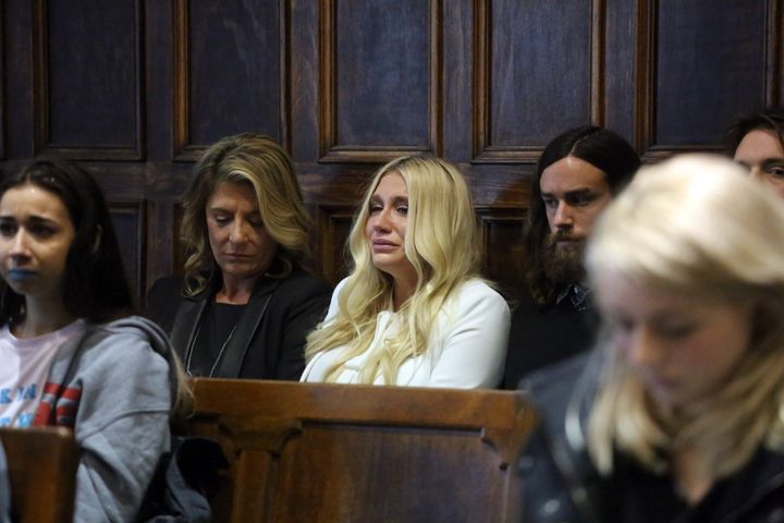 Kesha (center in white) cries as she learns she will not be released from her record label contract in Manhattan Supreme Court on Friday, February 19, 2016. A judge said she would not allow Kesha to leave her record label.