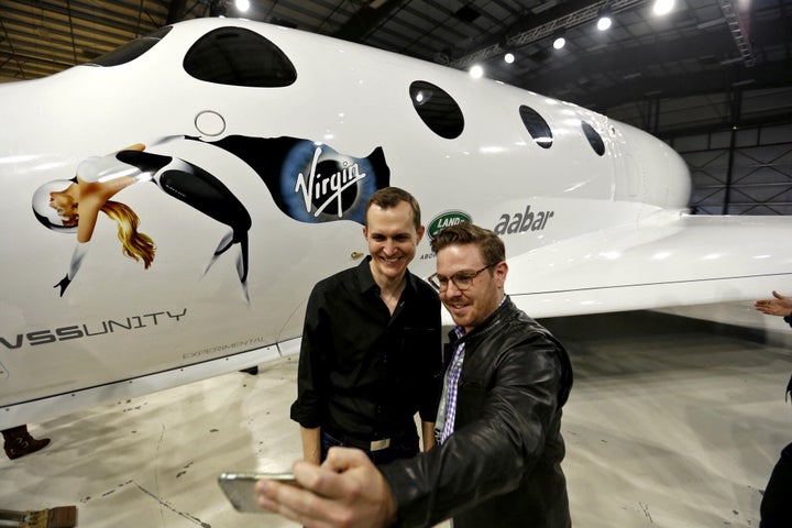 George Whitesides, left, CEO of Virgin Galactic and The Spaceship Company has a selfie taken with John Conafay, right, a guest at the new Virgin Galactic SpaceShipTwo roll out.