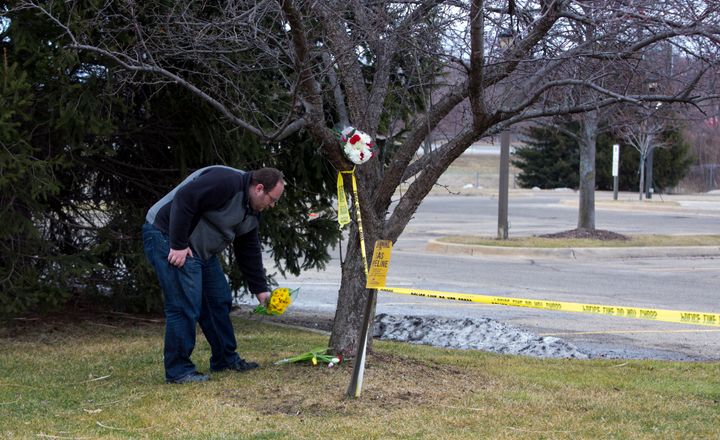 A man places flowers at a Cracker Barrel where four people were killed.