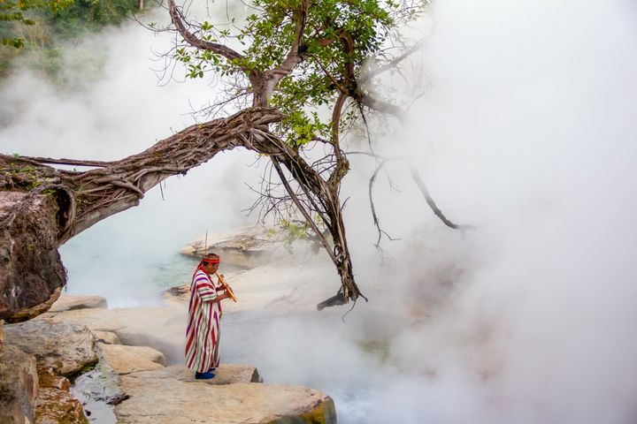 A shaman stands at the edge of the boiling river.