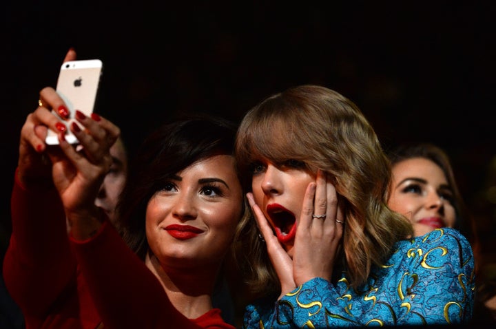 Recording artists Demi Lovato (L) and Taylor Swift take a selfie at the 2014 MTV Video Music Awards at The Forum on August 24