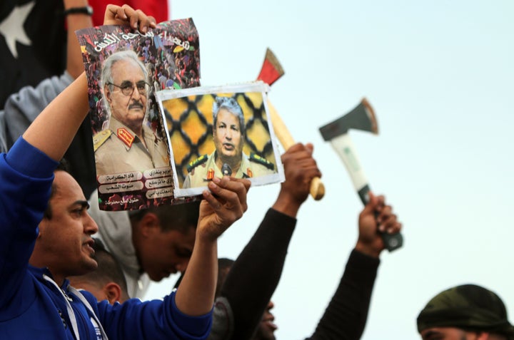 At left, a Libyan man holds a poster of General Khalifa Haftar, one of the UAE's top allies in Libya.