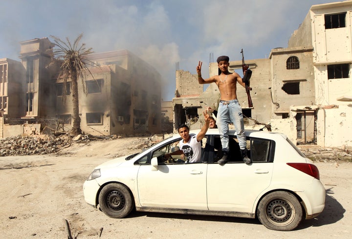 Fighters loyal to Libya's internationally recognized government celebrate as they come close to seizing the center of the eas