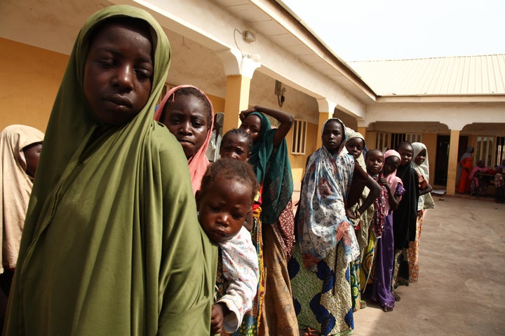 Girls rescued by Nigerian soldiers from Boko Haram line up to collect donated clothes at the Malkohi refugee camp.