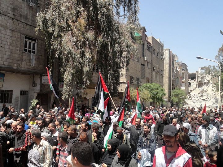 Salameh has been arrested several times for organizing and participating in demonstrations against Syrian President Assad. In this photo, people protest against Assad's forces blocking aid access to the Yarmouk refugee camp in Damascus.