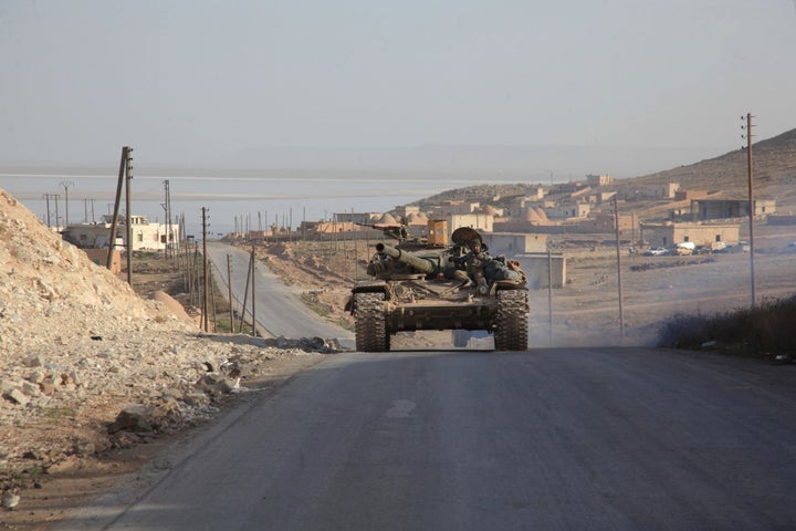 Syrian government forces drive a tank on a road during a military operation in the Aleppo area on Friday.