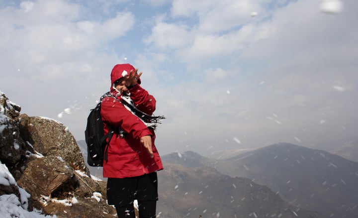 A young woman reacts&nbsp;as a friend throws a snowball at her during a morning hike.