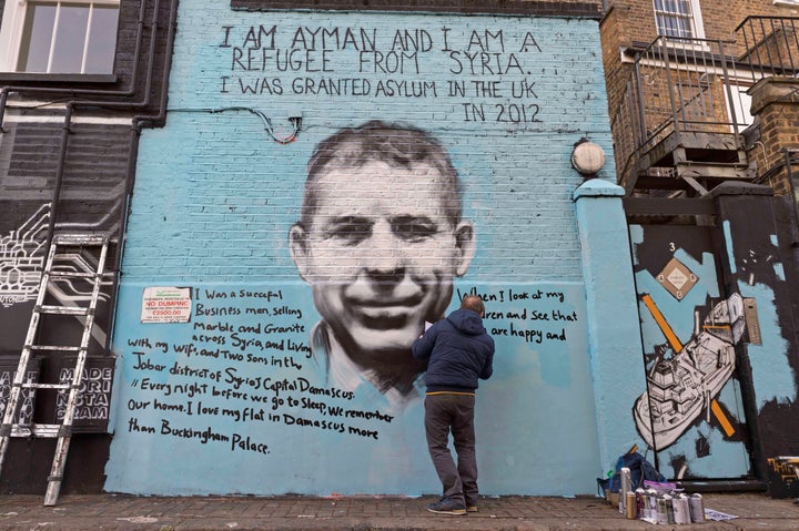 Ayman Hirh hand writes out his poignant messages on PANG's street mural in north London.