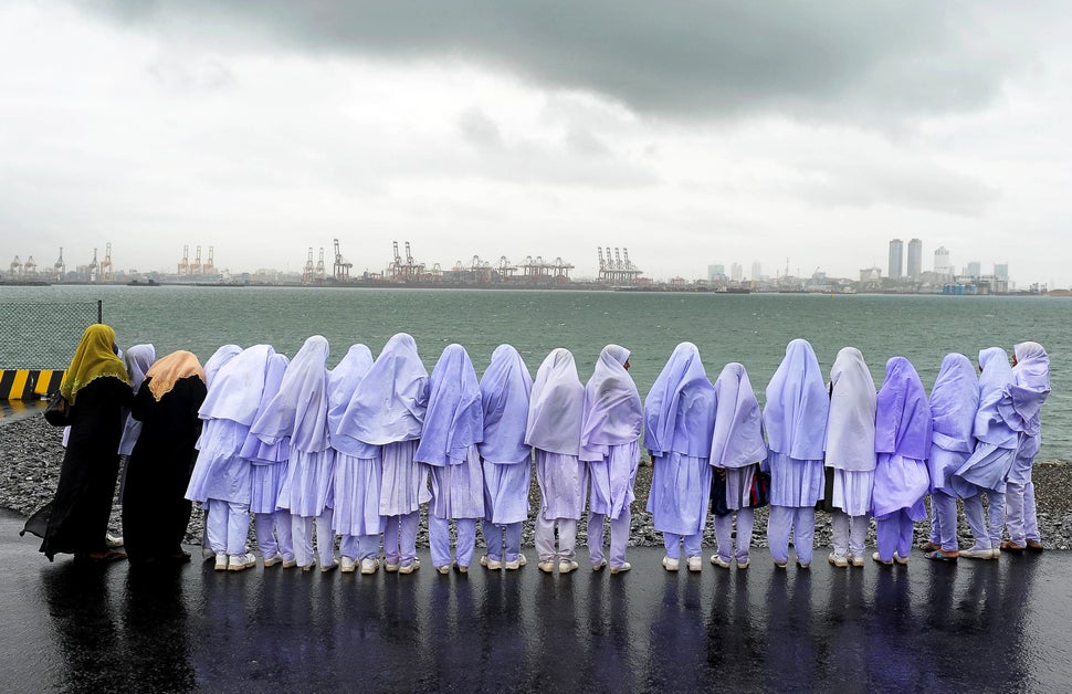 Sri Lankan Muslim school girls stand on the edge of a sea port in Colombo on May 20, 2013, after traveling from their town of