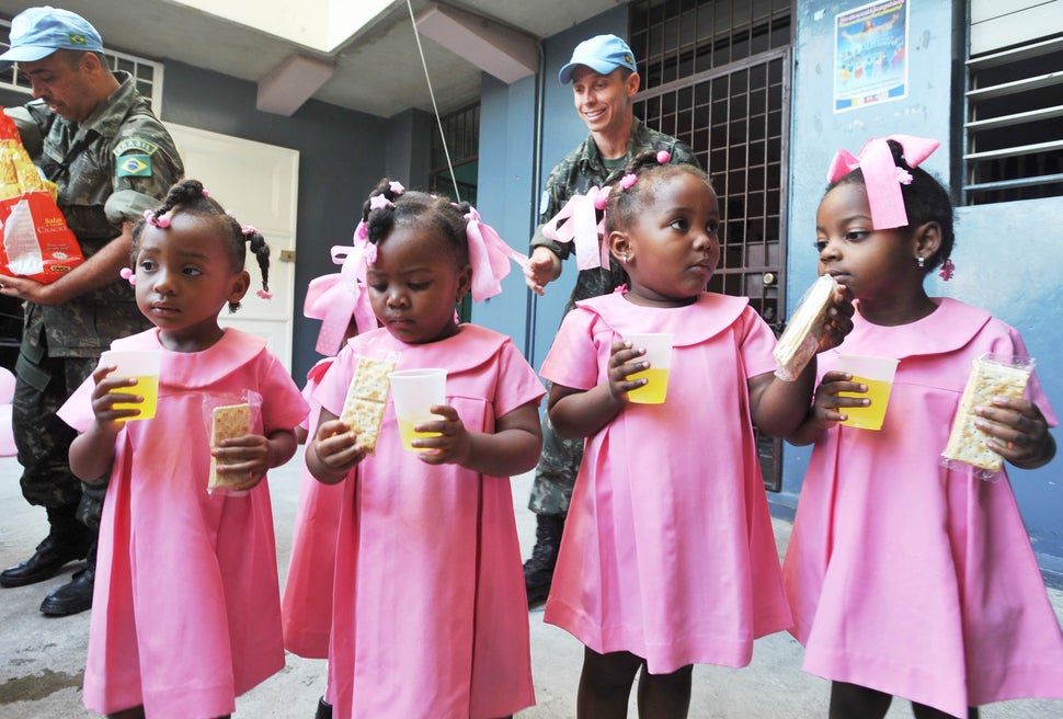 Brazilian UN peacekeepers distribute juice and crackers to students at the Immaculate Conception School February 6, 2013 in P