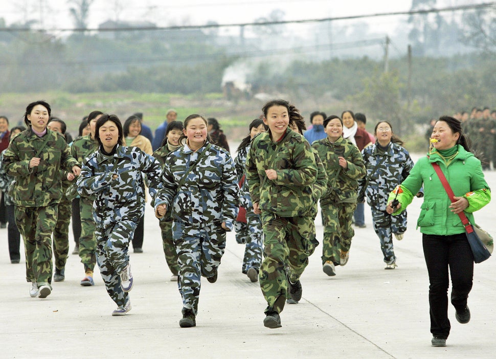 A class of students run during a physical training exercise at the temporary campus of the "Walking School" of Xu Xiangyang E