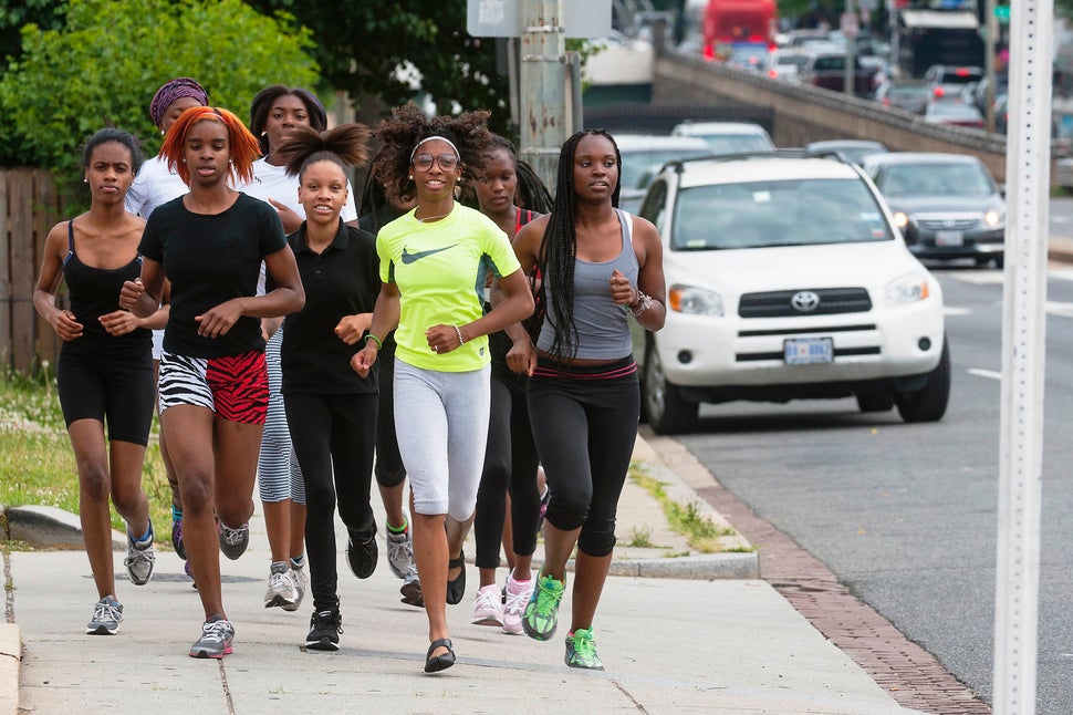 A girls' track team runs through traffic as they travel to McKinley High School where they practice on May 28, 2013 in Washin
