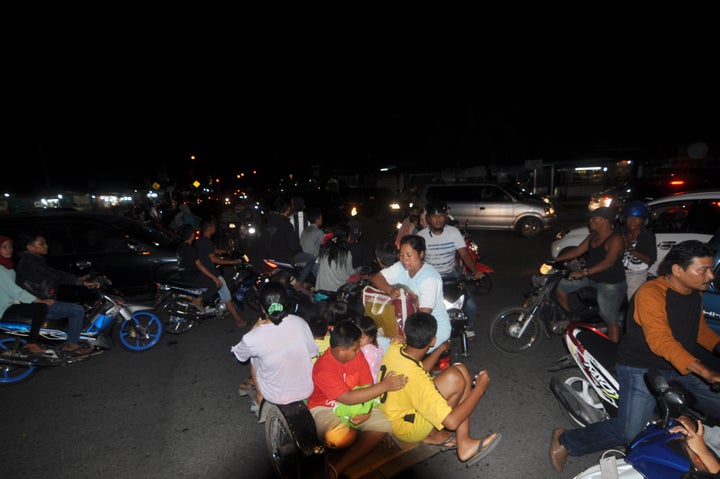 Indonesian residents use a variety of transport options as they rush to higher ground in Padang late March 2, 2016, after a powerful earthquake struck off the coast of the island of Sumatra.