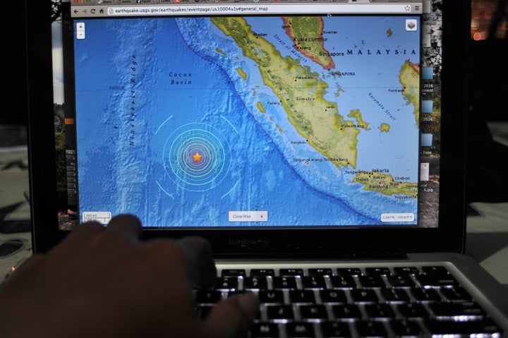 An Indonesia man read news of the earthquake that shook the Mentawai islands on the internet that just happened, in Jakarta,