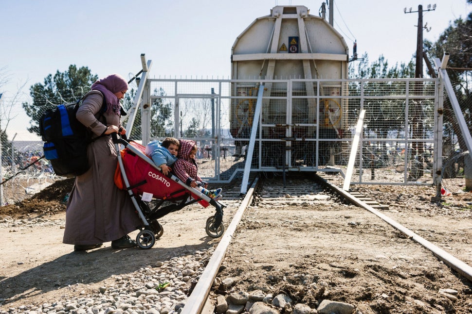 A woman pushes her children in a stroller after they cross the border between Greece and Macedonia. Since Balkan nations