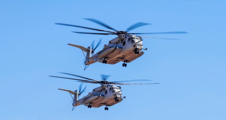 Two Marine Corps CH-53E Super Stallion helicopters fly in formation.