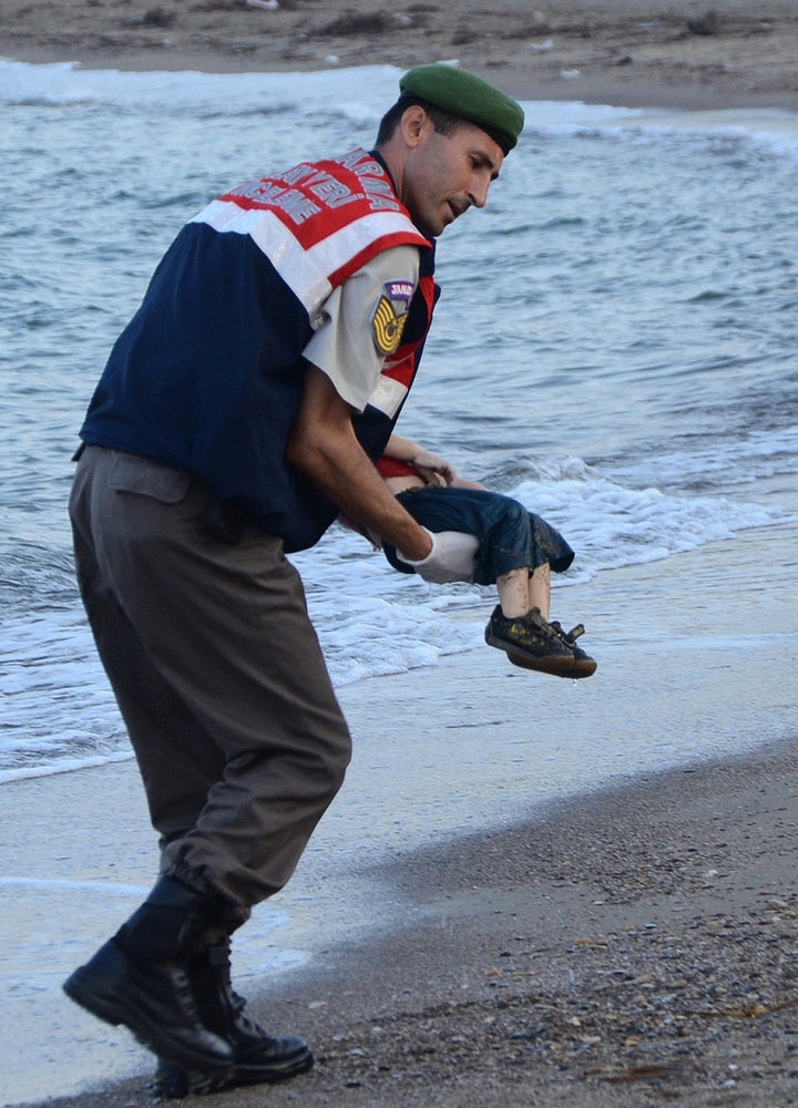 A Turkish police officer carried Aylan Shenu's body off the shores in Bodrum on Sept. 2, 2015.