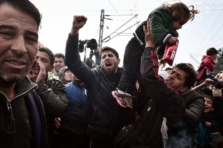 Protesters block a train coming from Macedonia at the overcrowded makeshift refugee camp in the Greek border town of Idomeni on March 3, 2016.