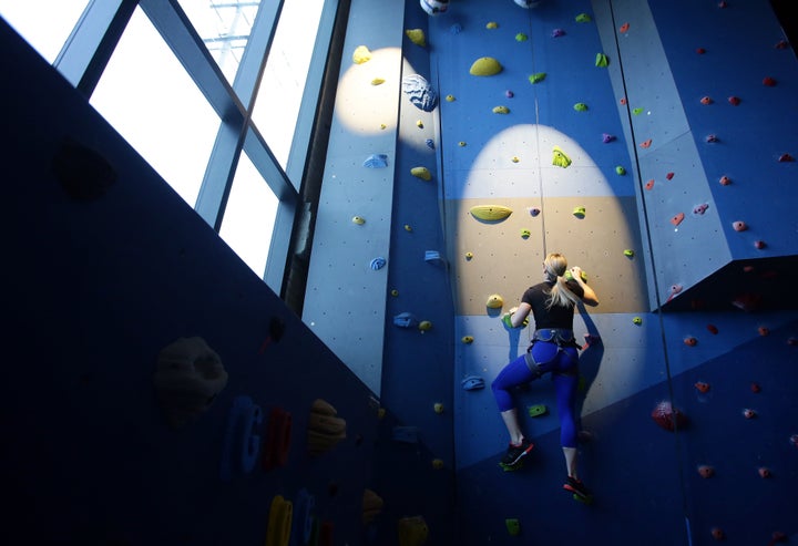 An employee climbs the rock wall in the fitness center at Google Canada's engineering headquarters in Waterloo, Ontario, Canada.