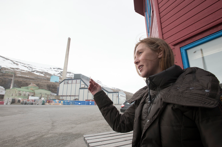 Elisabeth Larsen stands across the street from Longyearbyenâs coal burning power plant.