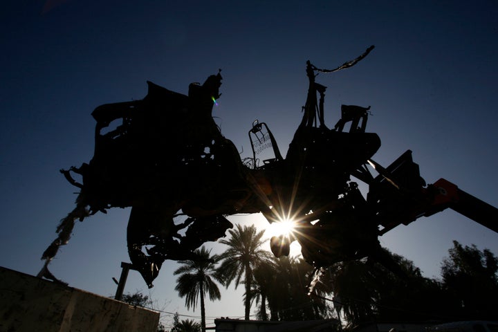 Iraqi emergency responders clear debris from the site of a truck bomb, that exploded at a crowded checkpoint, in the Iraqi city of Hilla, south of Baghdad on March 6, 2016.