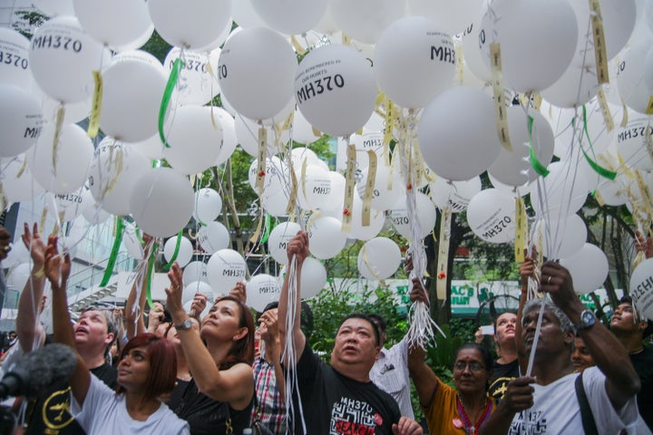 Relatives join a remembrance ceremony for their loved ones in Kuala Lumpur on Sunday.