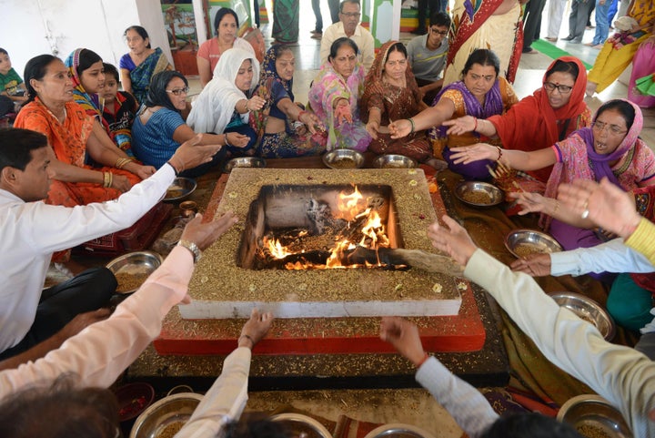 Indian devotees participate in a traditional "Yagna" ritual offering at a temple devoted to the deity Shiva to mark the Hindu