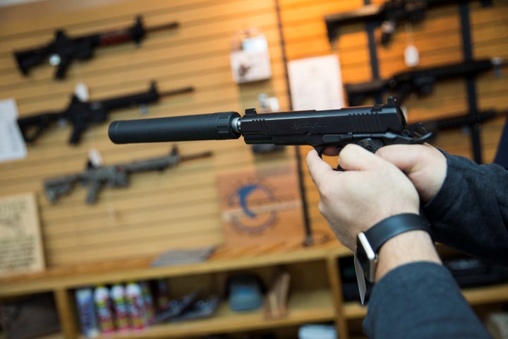 A customer tries out a Remington 1911 equipped with a silencer at Blue Ridge Arsenal in Chantilly, Va., in 2015. The gun indu