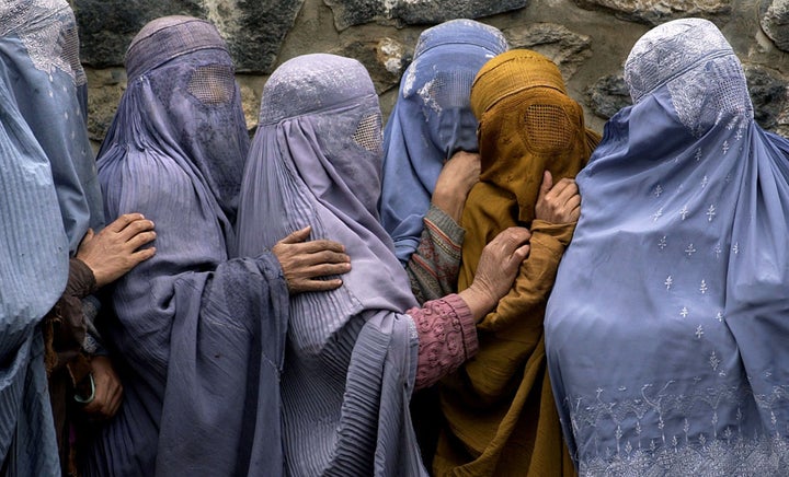Women waiting in line to receive food in the Afghan capital, Kabul, remain as covered up as when the Islamic fundamentalist T