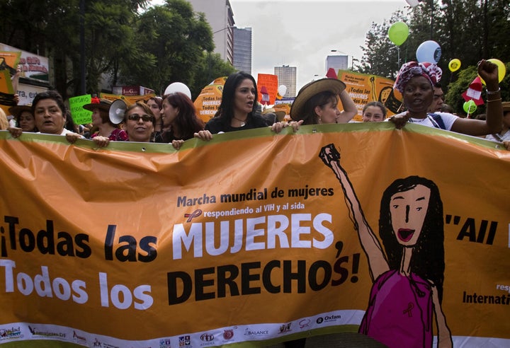 A group of women hold a banner during the Women's World March at the Zócalo square in Mexico City on Aug. 5, 2008, on