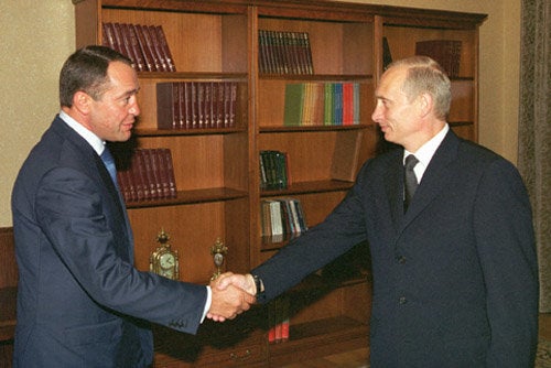 Mikhail Lesin shakes hands with Russian President Vladimir Putin. A medical examiner has determined Lesin died of blunt force