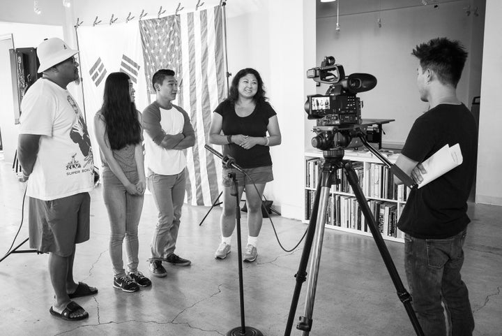 KAD Diaries subjects stand in front of the American and South Korean flags while being interviewed.