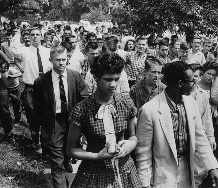 Dorothy Counts-Scoggins getting escorted out of Harding High School in 1957 as a crowd of students follows.