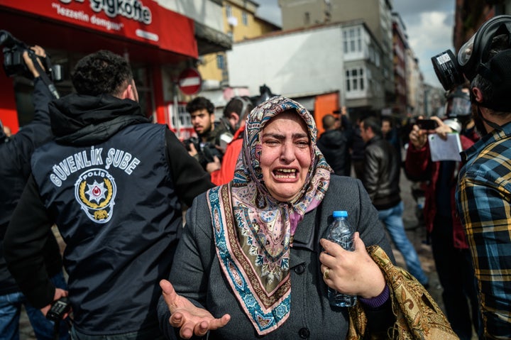 A woman cries as Turkish anti-riot police officers disperse supporters in front of the headquarters of the Turkish daily newspaper Zaman in Istanbul on March 5, 2016, after Turkish authorities seized the headquarters in a midnight raid.