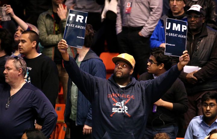A protestor holds a ripped Donald Trump sign up before the start of a rally for the Republican presidential candidate at the UIC Pavilion in Chicago on Friday, March 11, 2016