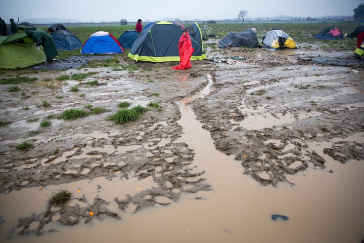 A boy stands besides his tent as rain falls at the Idomeni refugee camp on the Greek Macedonia border on March 12, 2016 in Idomeni, Greece