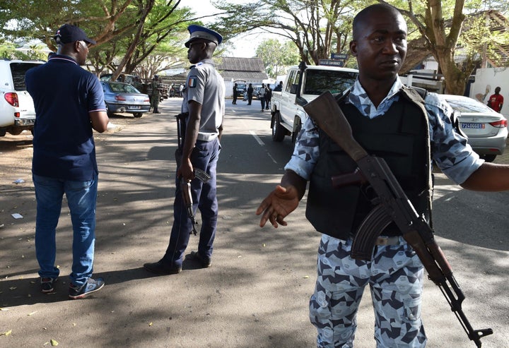 Ivorian armed forces take position as people leave the beach after heavily armed gunmen opened fire on March 13, 2016 at a hotel in the Ivory Coast beach resort of Grand-Bassam.