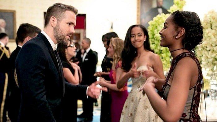 Ryan Reynolds meets Sasha Obama while Malia Obama looks on. 