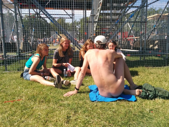 Nudist talking to women at an event.