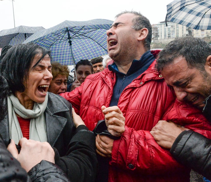 Family members and relatives of victims grieve outside a morgue on March 14, one day after a devastating car bomb ripped through central Ankara, killing dozens. 