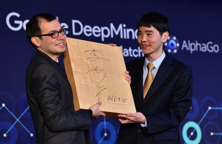 Lee Se-Dol (R), one of the greatest modern players of the ancient board game Go, presents the 'Go' game board with his signature to Google Deepmind head Demis Hassabis (L) during a closing ceremony after the fifth and final game of the Google DeepMind Challenge Match. Se-Dol lost four out of five games.