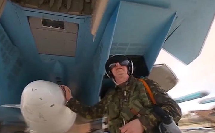 A fighter bomber pilot prepares to leave Syria's Hmeymim air base for Russia. Putin said Russia had largely fulfilled its obj