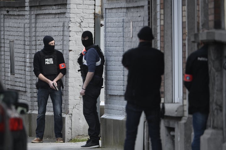 Police officers stand at the site of a shooting on Dries-Driesstraat at Forest-Vorst in Brussels on March 15, 2016